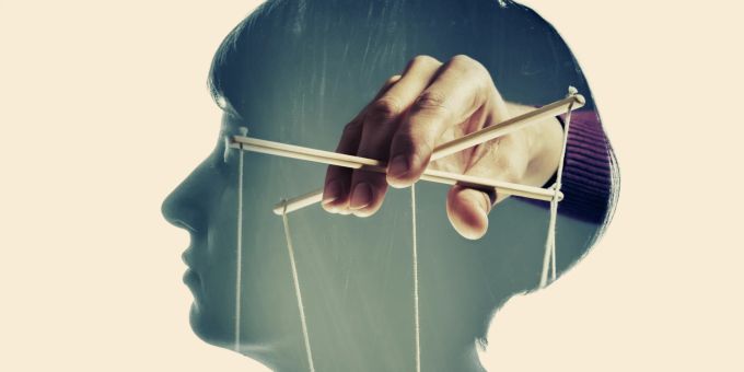Beim Gaslighting wird eine Person bewusst vom romantischen Partner manipuliert. marionette hand fäden kopf