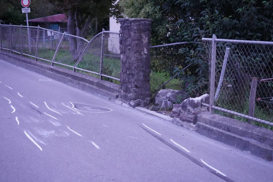 Das Auto schrammt einem Zaun und einer Gartenmauer entlang.