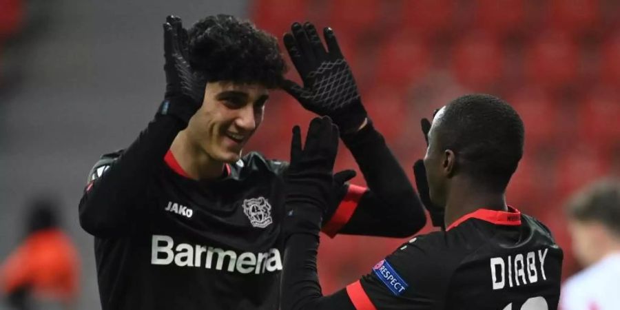 Erhält bei Bayer Leverkusen einen Profivertrag: Emrehan Gedikli (l) klatscht nach einem Treffer in der Europa League mit dem Torschützen ab. Foto: Ina Fassbender/AFP/Pool/dpa