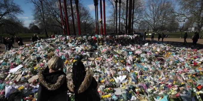 Zwei Frauen schauen sich die Blumen an, die für die getötete Sarah Everard im Clapham Common Park in London niedergelegt wurden. sarah everard