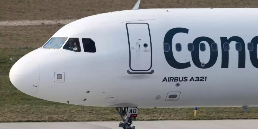 Der Pilot einer Condor-Maschine mit Ziel Teneriffa winkt dem Bodenpersonal vor dem Start vom Flughafen Leipzig/Halle. Foto: Jan Woitas/dpa-Zentralbild/dpa