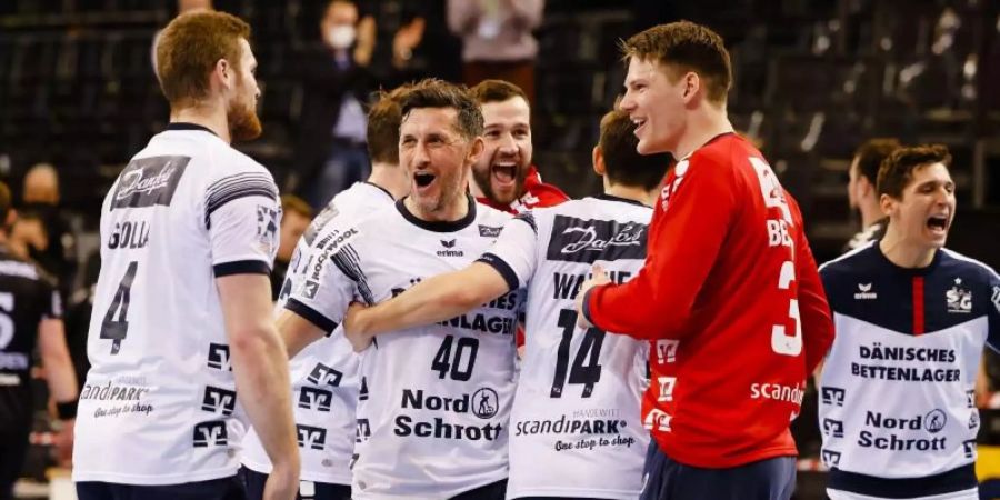 Die Flensburger Spieler feiern den Sieg gegen Kiel. Foto: Frank Molter/dpa