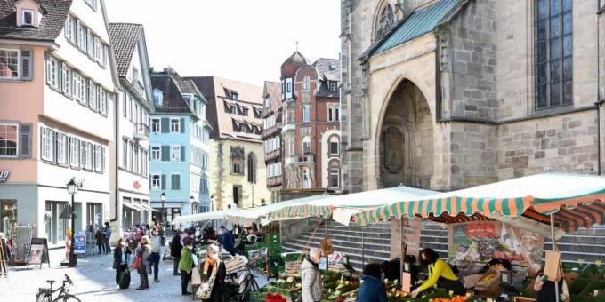 Passanten gehen in der Fussgängerzone an Marktständen vorbei. Foto: Bernd Weissbrod/dpa Passanten gehen in der Fussgängerzone an Marktständen vorbei. Foto: Bernd Weissbrod/dpa