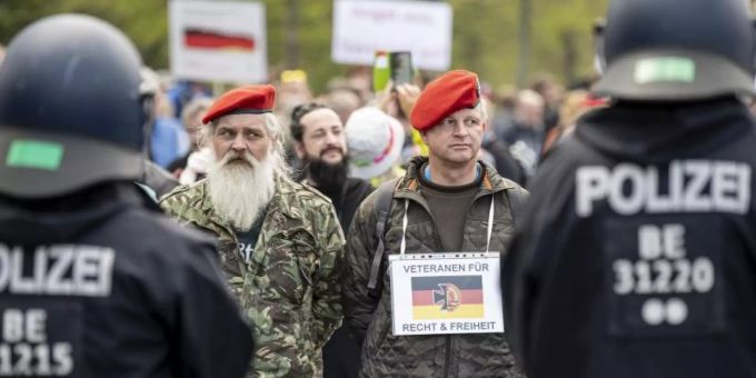 Zwei Demonstranten stehen mit einem Schild - «Veteranen für Recht und Freiheit» - auf der Strasse des 17. Juni in Berlin. Foto: Fabian Sommer/dpa Zwei Demonstranten stehen mit einem Schild - «Veteranen für Recht und Freiheit» - auf der Strasse des 17. Juni in Berlin. Foto: Fabian Sommer/dpa