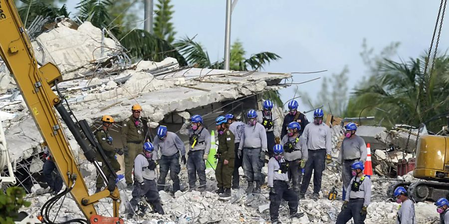 Rettungskräfte arbeiten an der Stelle des eingestürzten Champlain Towers South Condo Gebäudes. Foto: Lynne Sladky/AP/dpa