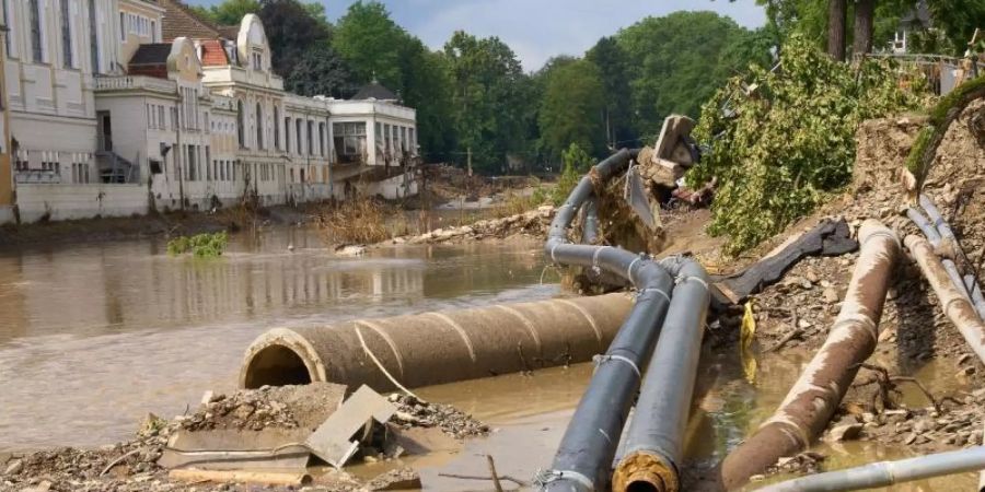 Weggeschwemmte Versorgungsleitungen liegen am Ufer der Ahr. Mit dem Hochwasser Mitte Juli sind insgesamt auch rund 350 Kilogramm Munition aus dem Zweiten Weltkrieg freigespült worden. Foto: Thomas Frey/dpa