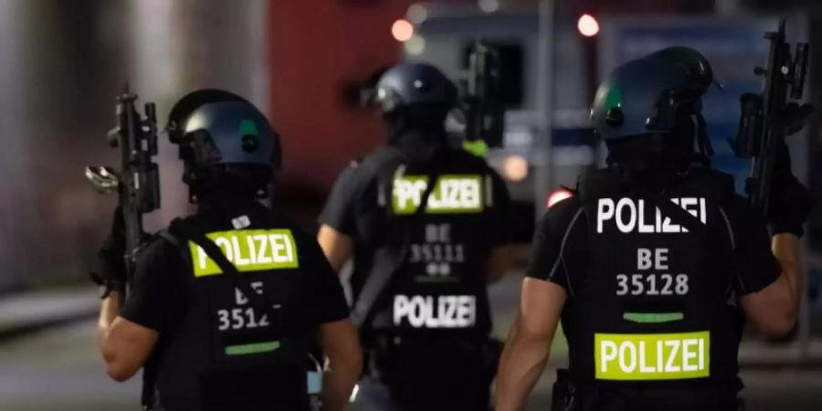 Polizisten mit Maschinenpistolen suchen auf dem Gelände eines Baumarktes in Berlin-Wedding nach Verdächtigen. Foto: Paul Zinken/dpa-Zentralbild/dpa