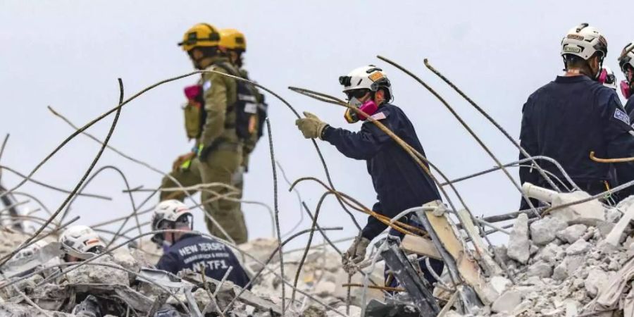 Rettungskräfte arbeiten sich durch die Trümmern des teilweise eingestürzten Wohnkomplexes. Noch immer werden Dutzende Menschen vermisst. Foto: Al Diaz/Miami Herald/AP/dpa