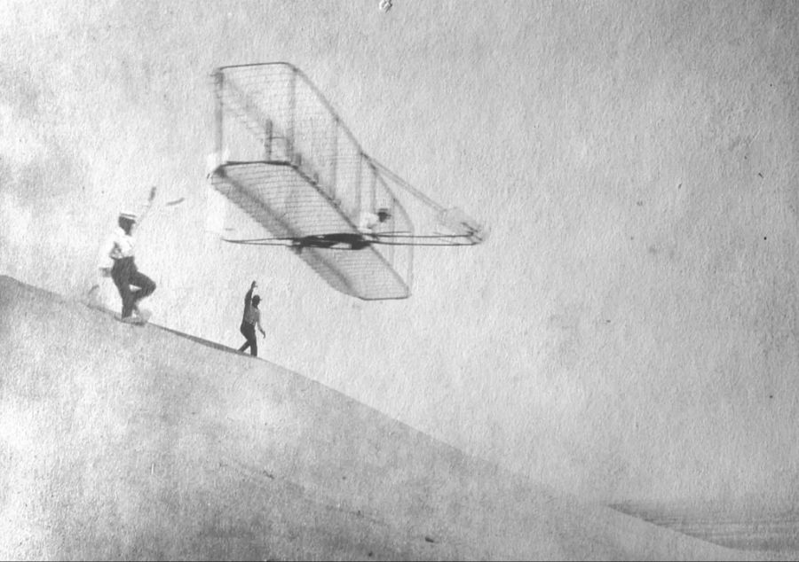 Die Gebrüder Wright 1902 bei Flugexperimenten in Kitty Hawk, North Carolina. 1903 wird ihnen dank Dreiachssteuerung der aerodynamisch kontrollierte Motorflug mit einer Maschine «schwerer als Luft» gelingen.