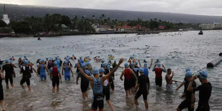 2019: Athleten stehen im Wasser der Kailia Bay für den Schwimmteil des Triathlons. Foto: Marco Garcia/FRE 132414 AP/dpa