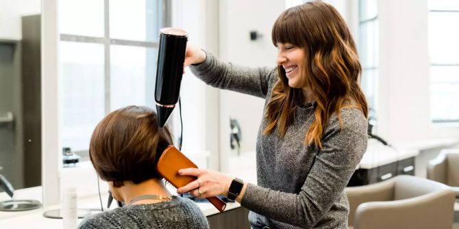 Frau föhnt Haare