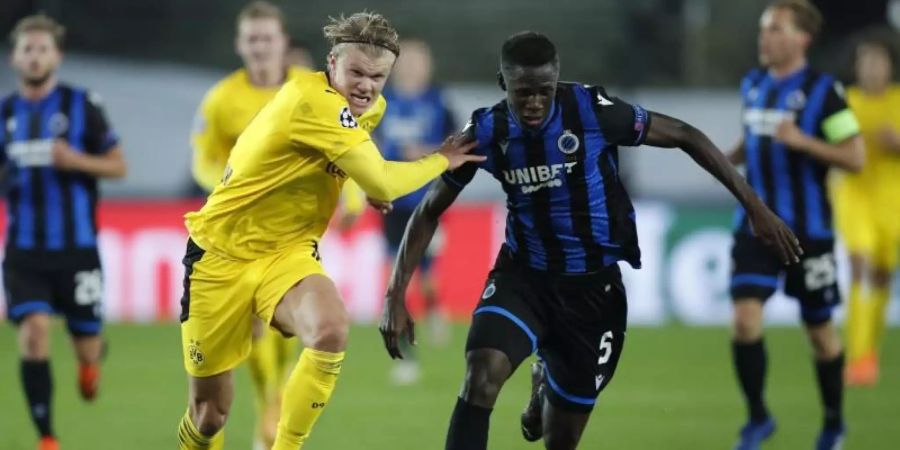 Odilon Kossounou vom FC Brügge (r) im Zweikampf mit dem Dortmunder Erling Haaland. Foto: Francisco Seco/AP/dpa