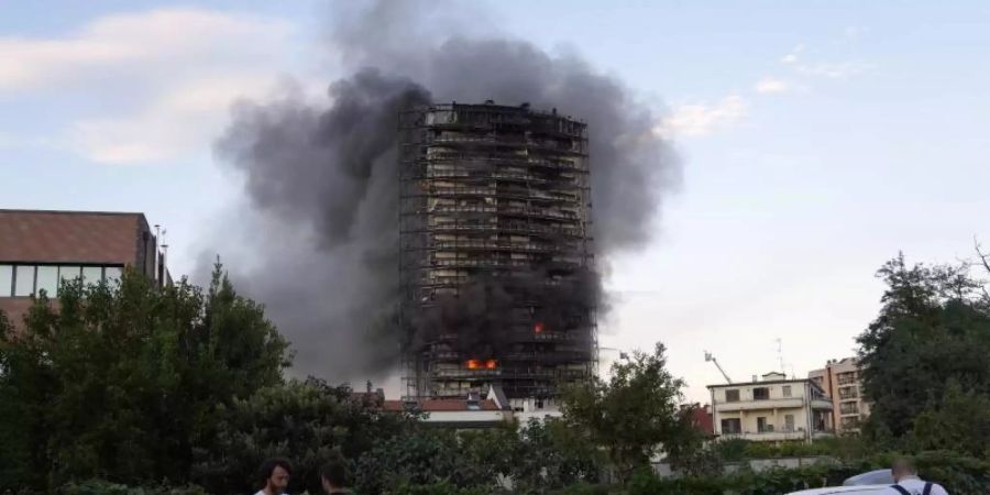 Ein Brand hat am Sonntagnachmittag ein Hochhaus am südlichen Stadtrand von Mailand zerstört. Foto: Luca Bruno/AP/dpa