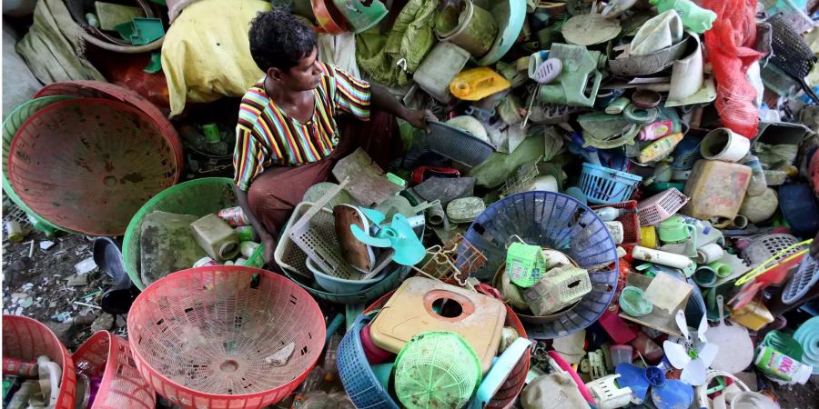 Ein Arbeiter trennt Plastikmüll in einem Sammellager in Myanmar.