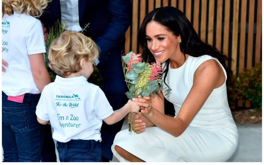 Ein vierjähriger Bub schenkt Herzogin Meghan Blumen.