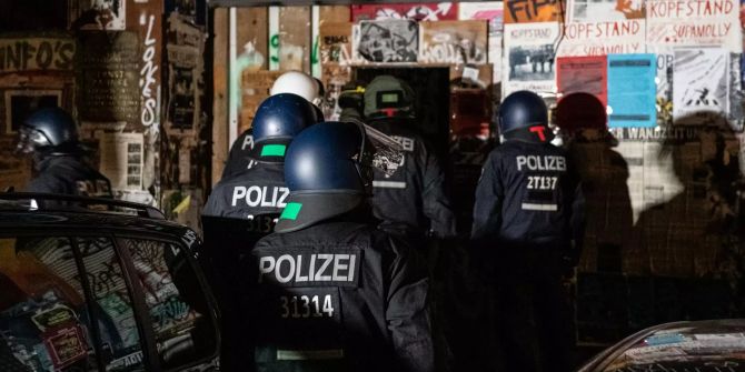 Polizeibeamte gehen bei einer Razzia in der Rigaer Strasse in Berlin-Friedrichshain in ein Haus.