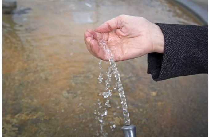 Hand unter fliessendem Brunnen - Keystone Hand unter fliessendem Brunnen - Keystone