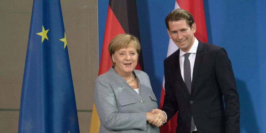 Die deutsche Bundeskanzlerin Angela Merkel (CDU) und und der österreichische Bundeskanzler Sebastian Kurz geben sich nach einer gemeinsamen Pressekonferenz in Berlin die Hand.