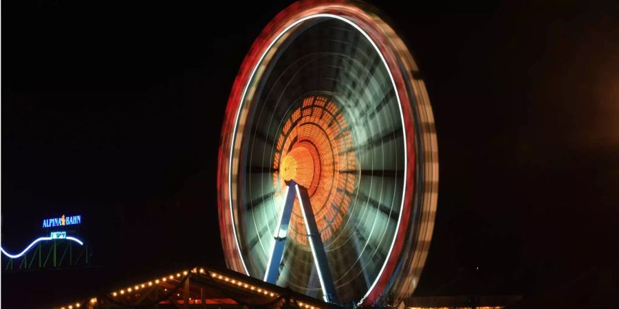 Ein Riesenrad ist bei Nacht auf dem Oktoberfest zu sehen.