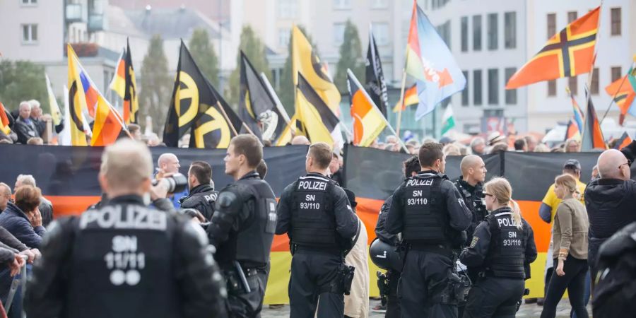 Polizisten stehen vor einer Pegida-Demonstration.