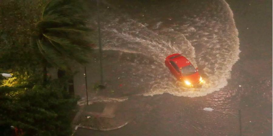 Ein Auto fährt während heftiger Regenfälle und starken Winden, die durch den Taifun «Mangkhut» verursacht wurden, über eine überflutete Strasse in Manila.