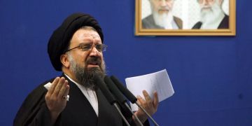 Ajatollah Ahmad Khatami spricht neben den Bildern von Ayatollah Ruhollah Khomeini.