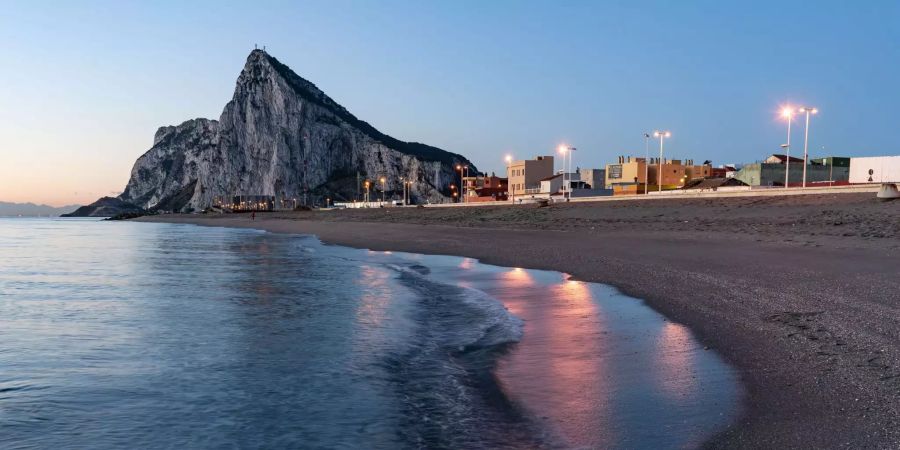 Der Felsen von Gibraltar steht vor Sonnenaufgang am Ende der Landzunge.