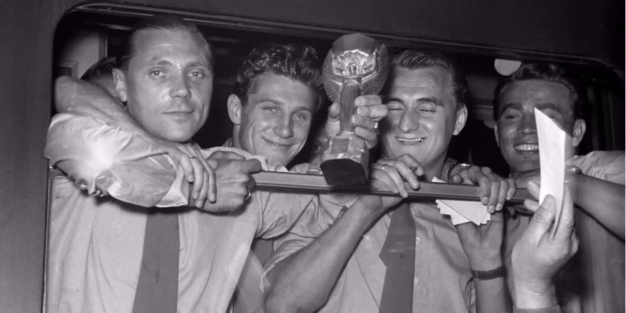 Schäfer (zweiter von links) mit seinen Mannschaftskollegen und dem gewonnen WM-Pokal 1954.