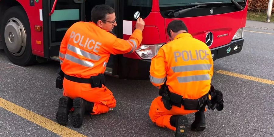 Polizisten untersuchen die Stelle, an der der Aufprall stattfand.