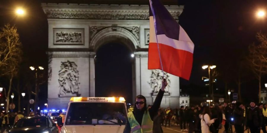 Demonstrant mit Trikolore vor Triumphbogen