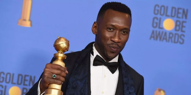 Mahershala Ali zeigt seinen Award.