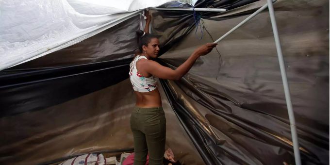 Eine venezolanische Migrantin baut ein Zelt auf, nachdem sie von Venezuela nach Quito geflohen war. Eine venezolanische Migrantin baut ein Zelt auf, nachdem sie von Venezuela nach Quito geflohen war.