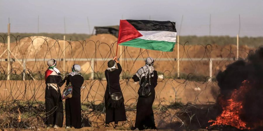 Vier Palästinenserinnen protestieren an der Grenze zu Israel.