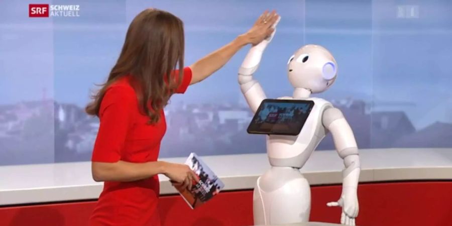 Bigna Silberschmidt und Roboter Pepper geben sich ein High Five.