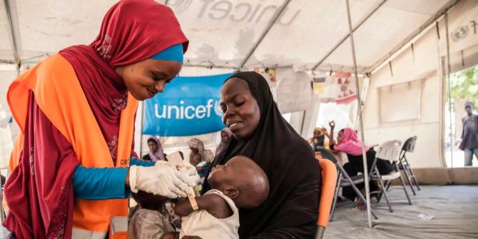 Eine Unicef-Ernährungsbeauftragte behandelt ein unterernährtes Kind.