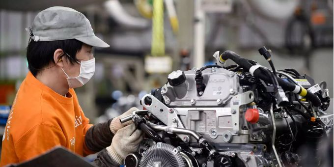 Ein Arbeiter steht in einem japanischen Werk von Mitsubishi in der LKW-Produktion. Ein Arbeiter steht in einem japanischen Werk von Mitsubishi in der LKW-Produktion.
