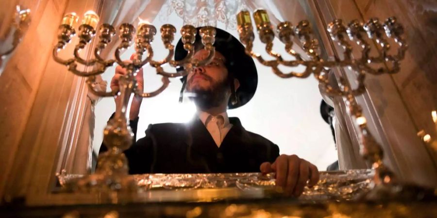 Ein Rabbiner zündet die Kerzen an.