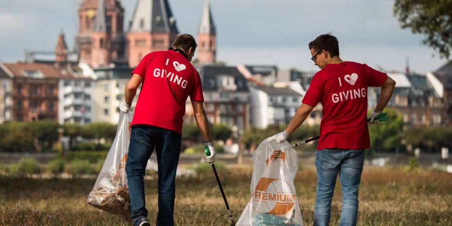 Zwei Mitarbeiter des Chemieunternehmens Celanese befreien im Vorfeld des «World Cleanup Day», mit dem Mainzer Dom im Hintergrund, die Maarauen von Müll.