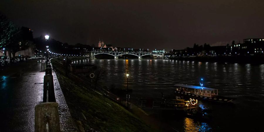 Ein Fähre fährt bei Nacht auf dem Rhein in Basel.