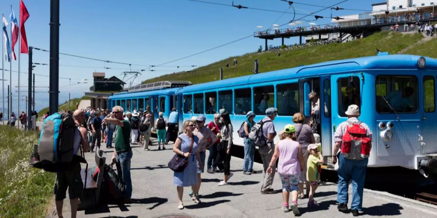 Menschen warten in Rigi Kulm auf die Rigi Bahn.