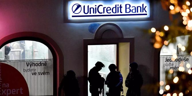 Polizisten stehen vor einer Bankfiliale der UniCredit Bank.