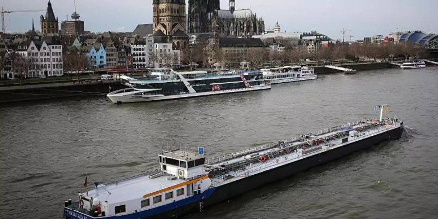 Ein Binnenschiff fährt vor dem Dom über den Rhein. Foto: Oliver Berg