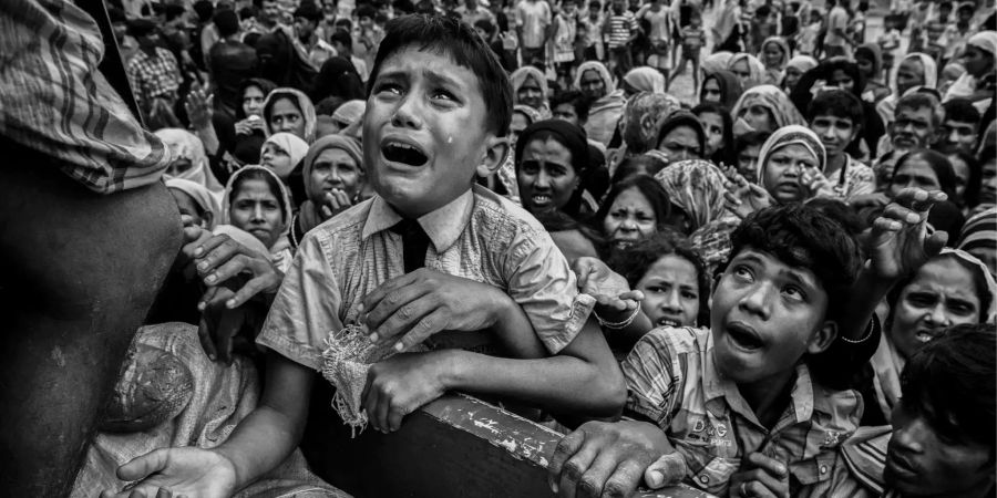 Das drittplatzierte Foto zeigt einen weinenden Rohingya-Jungen, der bei der Ankunft des Lebensmitteltransports in einem Flüchtlingslager der Rohingya am Golf von Bengalen hoffnungsvoll seine Hand aufhält.