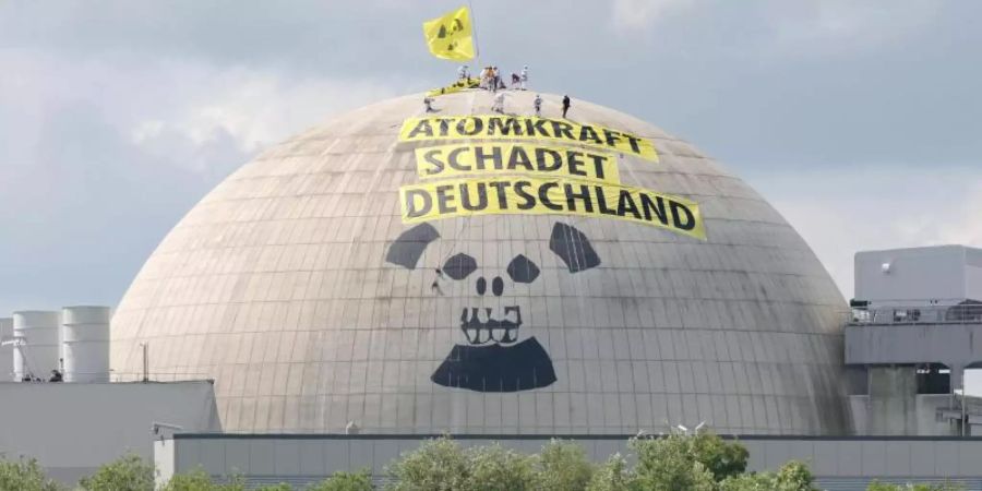 Zwanzig Aktivisten der internationalen Umweltschutzorganisation Greenpeace befinden sich auf der Kuppel des Reaktorgebäudes des Atomkraftwerkes Unterweser in der Wesermarsch. Foto: Ingo Wagner/dpa