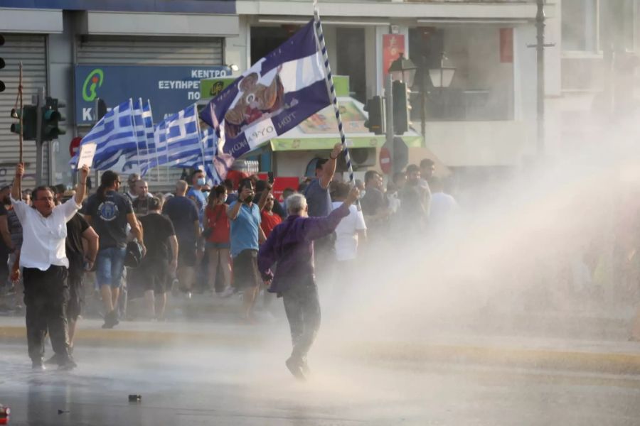 Die Polizei drängt Protestler in Athen mit Wasser weg.