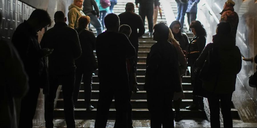 Menschen suchen Schutz im Eingang einer U-Bahn-Station nach einem Raketenangriff. Foto: Francisco Seco/AP/dpa