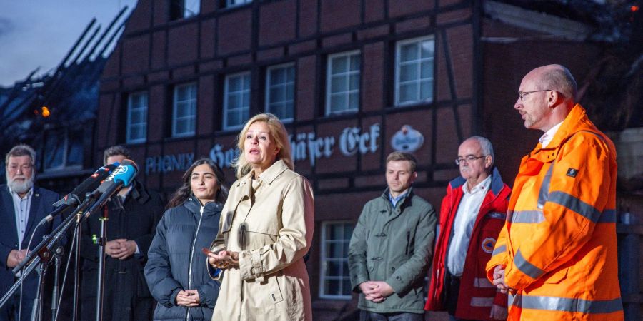 Bundesinnenministerin Nancy Faeser (SPD) und Mecklenburg-Vorpommerns Innenminister Christian Pegel (SPD) beantworten vor dem abgebrannten Hotel Fragen von Journalisten.