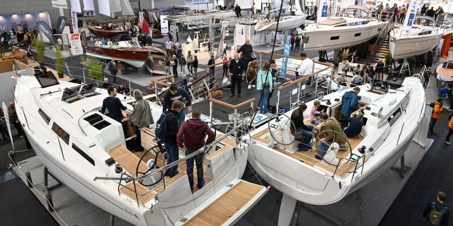 Besucher schauen sich in der Messehalle A3 verschiedenen Segelboote an.