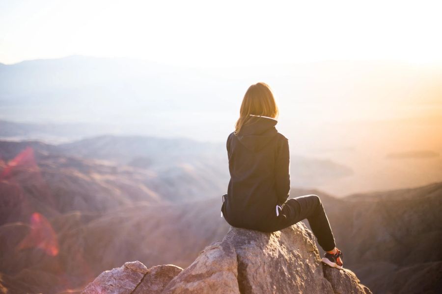 Frau sitzt auf Felsen