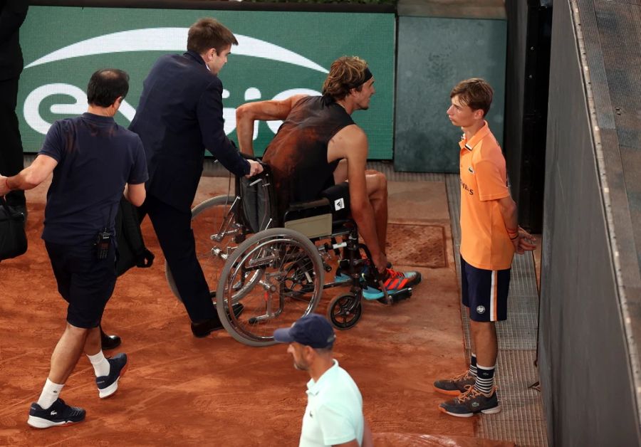 Alexander Zverev wird im Rollstuhl vom Platz gebracht.